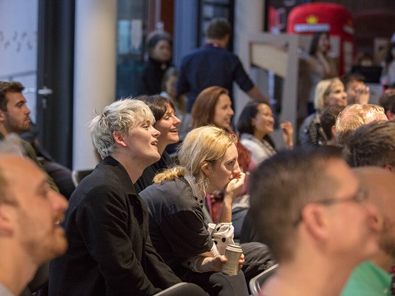 A seated audience watching a talk at The Postal Museum.